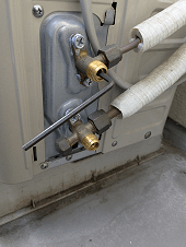 冷媒ガス回収ポンプダウンで高圧バルブを閉栓する写真